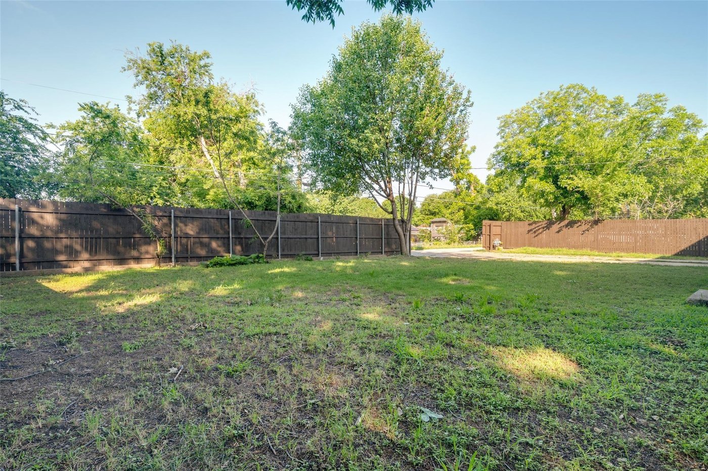 Private fenced backyard shaded by mature trees at 4401 Ivy Dr, Mesquite