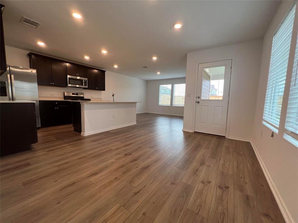 Open concept kitchen and living area at 7224 Spotted Leaf Way, Del Valle TX